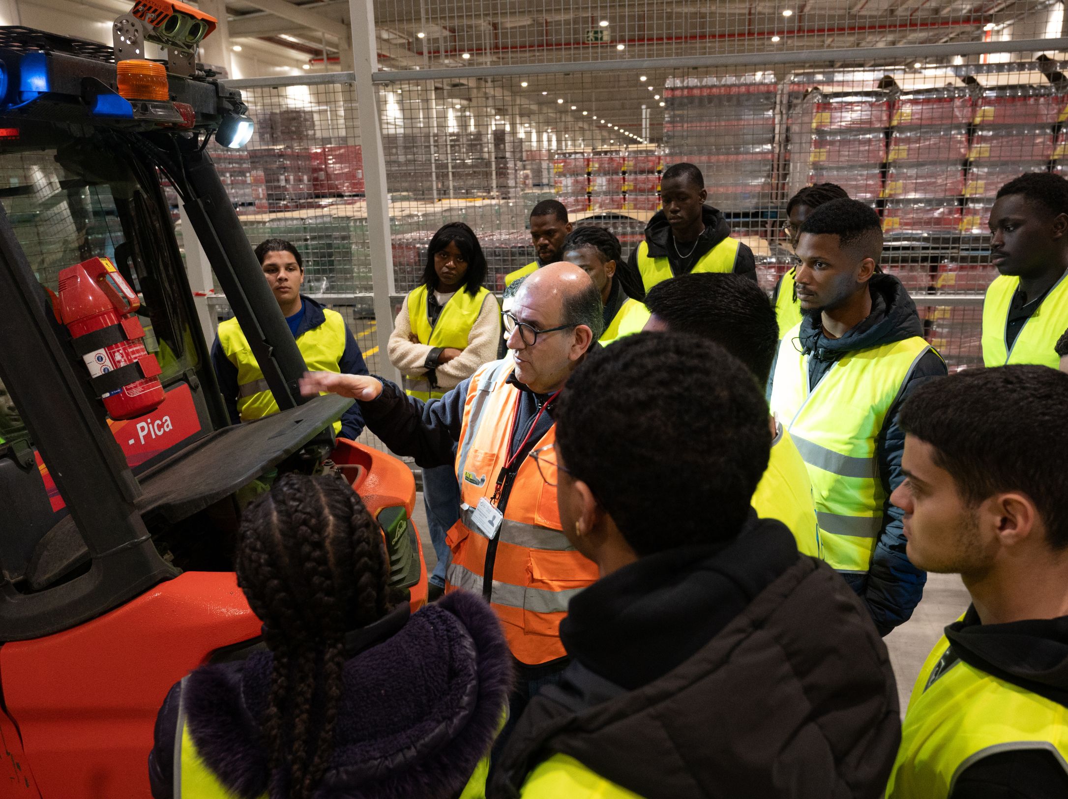 Jovens do 'BORA Jovens, programa de empregabilidade jovem da Ajuda em Ação em Portugal, participam numa formação certificada de manobradores de máquinas, em contexto de trabalho, acompanhados por um formador na fábrica da Coca-Cola EP, financiadora do programa de empregabilidade e parceira da Ajuda em Ação.